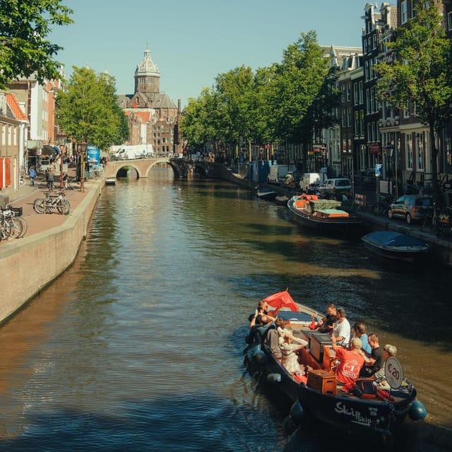 COZY AND FUN CANAL TOUR: A UNIQUE JOURNEY THROUGH AMSTERDAM - Magere Brug and the Munttoren